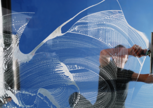 worker cleaning a window from outside